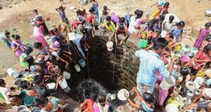 Impact of the Water Crisis: Villagers throw containers attached to ropes into a well to collect their daily supply of potable water after a tanker made its daily delivery at Shahapur, Maharashtra.